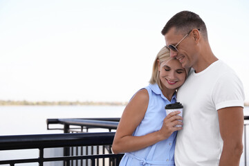 Happy couple with drink on city waterfront