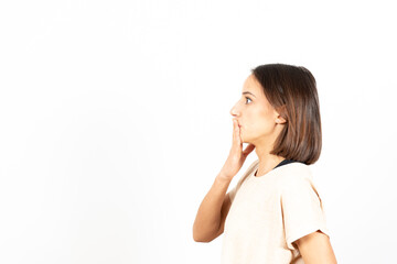 Side view of a latin woman covering her mouth and regreting something she has said.