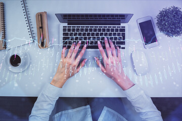 Double exposure of woman hands working on computer and forex chart hologram drawing. Top View....