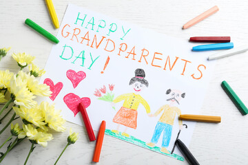 Beautiful drawing with phrase Happy Grandparents Day on white table, flat lay