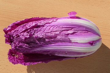 Lilac chinese cabbage, or napa cabbage, on wooden base to cut as cooking garnish