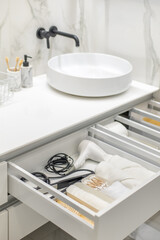 Bathroom under sink organizer drawers with neatly placed bath amenities and toiletries.