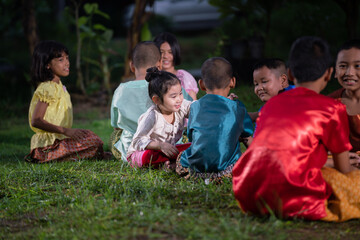 Group of Asian children in traditional costumes playing outdoor activities. local traditional game in Thai culture concept. 