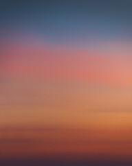 Smooth gradient of the evening sky with dramatic sunset colors. Colorful background texture. Clear sky. Pink, orange, yellow and blue colors. No clouds. Beautiful soft light. Twilight Nightfall Night 