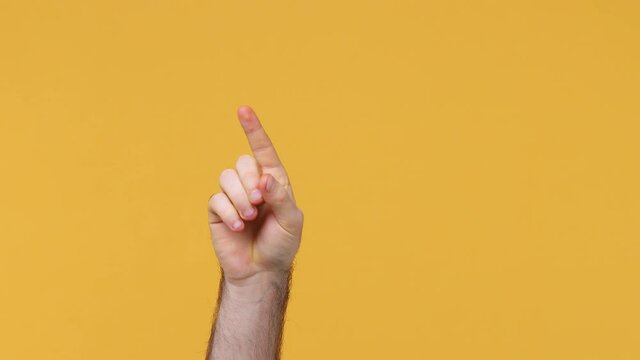 Cropped close up man male hand touch something like push click on button finger pointing at floating virtual screen isolated on yellow background studio. Copy space commercial promo workspace mock up