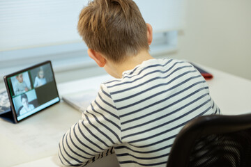 Fototapeta na wymiar Teenager schoolboy at virtual lesson at home using tablet during homeschooling at pandemic quarantine