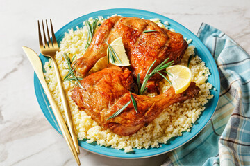 Chicken leg quarters over the millet on a plate