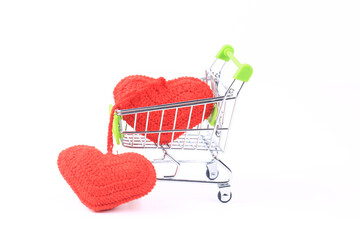 two knitted hearts in a shopping cart on a white background. creative valentines day concept