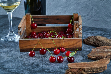 Red fresh juicy cherries in a wooden box