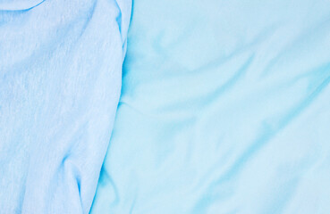 Blue fabric top view. Pastel colored textile photo texture. Folded fabric with wrinkles for pattern...