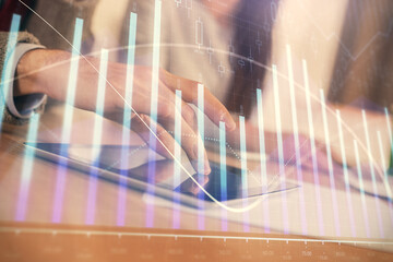 Double exposure of forex graph drawing and man and woman working together holding and using a mobile device. Trade concept.