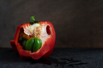 Cut red bell pepper with small peppers