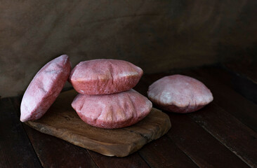Four pink pita breads on dark background