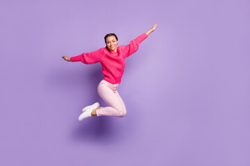 Fototapeta na wymiar Full size profile side photo of happy cheerful young woman jump up air hands wings isolated on violet color background
