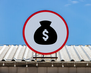 A Circle billboard with icon a money bag with symbol of dollar, is installed on a roof. Board with...