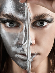 the girl removes a silver-colored cosmetic mask from her face - 408525172