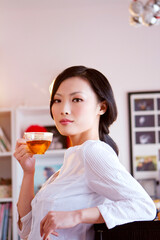 The young woman drinks tea in the living room