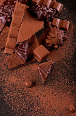 chocolate pieces and cocoa powder on wooden background