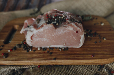 Fresh meat and pepper peas on the wooden cutting board and burlap close up