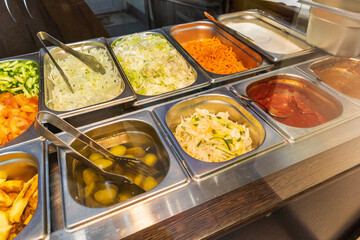 counter in the food canteen carrot cucumber tomato potato jalapeno sauces