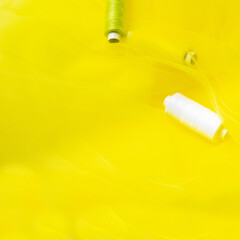 Tailoring concept. beautiful yellow fabric with sewing green thread. Top view. Flat lay. copy space