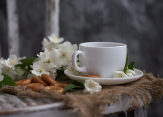 Cup of tea with jasmine flowers on a vintage chair
