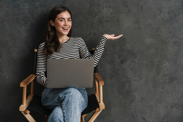 Smiling attractive young woman sitting with laptop