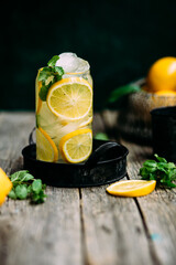 Lemonade with ice and mint in a glass glass on a wooden table