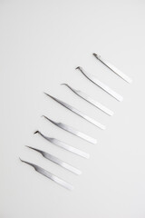 tools for eyelash extension and eyebrow design. cosmetic tweezers in silver color on a white background