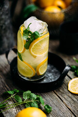 Lemonade with ice and mint in a glass glass on a wooden table
