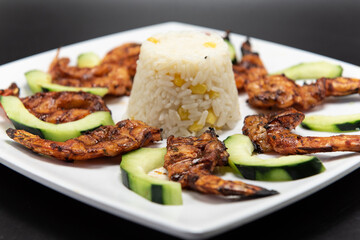 Shrimp zarandeado arranged in perfect presentation and garnished with sliced cucumbers on a plate
