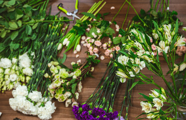 Attractive young woman florist is working in a flower shop.