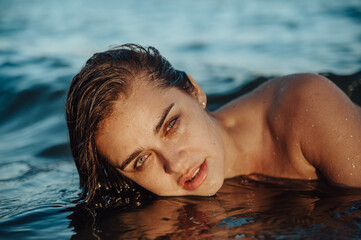 beautiful woman at sunset in water