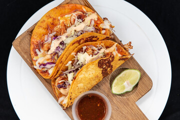 Overhead view of Mexican tacos encabronados served with shrimp on a wooden cutting board.
