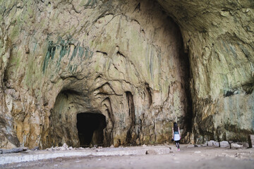 Traveler girl in front of the cave entrance, exploration a devetashka cave near lovech