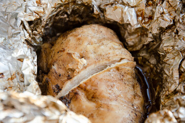 Juicy baked chicken fillet in foil in the oven. Appetizing chicken cooked in foil. Home kitchen....