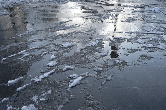 High angle shot of melting snow on the street under the sunlig