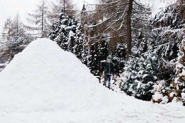 View of an snow igloo in a winter landscape and boy playing