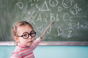 Child Girl Pointing School Blackboard. High quality photo