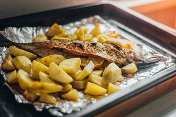 Homemade food, fish mackerel baked with potatoes in foil
