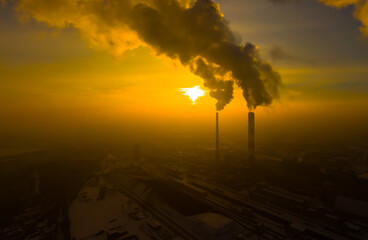 Power Plant emissions seen above the city  during sunrise. Environmental pollution. Factory pipe polluting air.Panorama sunset. Smoking pipes Aerial view,