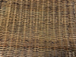 Texture of beige rattan wicker basket is made in form of large weave. Can be used as rug when entering house. Original background close-up 