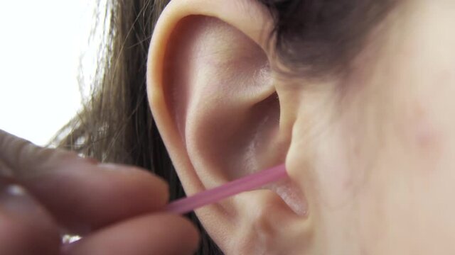 Close up footage of woman cleaning ears over white background