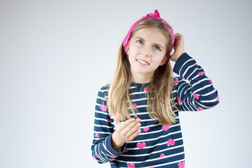 Little girl thinking and looking up, confused about an idea.