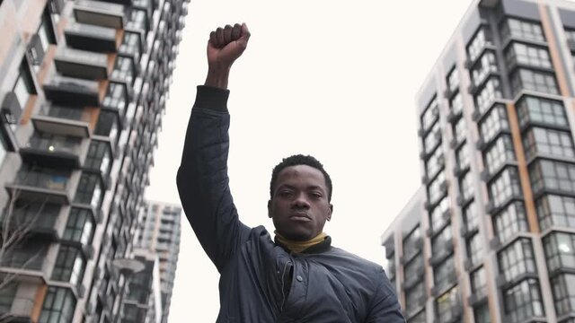 Young african american man rasises his first in solidarity for social and racial justice. Black lives matter. Social and racial justice concept 4k