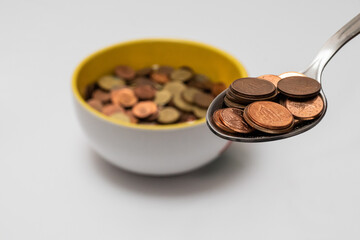 A plate full of coins and a spoon ready for eating