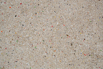 Texture of a beige wall from small stones and multicolored stones