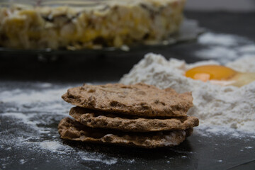 The process of making a cake. Cake cakes, flour and raw egg on a dark background