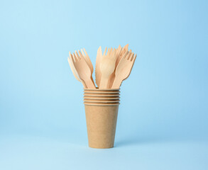 wooden fork and brown paper cup on a blue background
