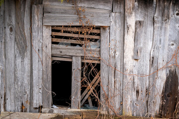 Fototapeta na wymiar Old abandoned wooden house with broken window